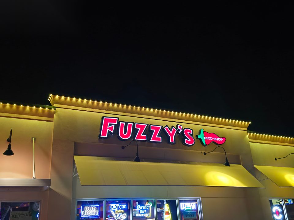 Restaurant storefront sign with warm white permanent accent lighting