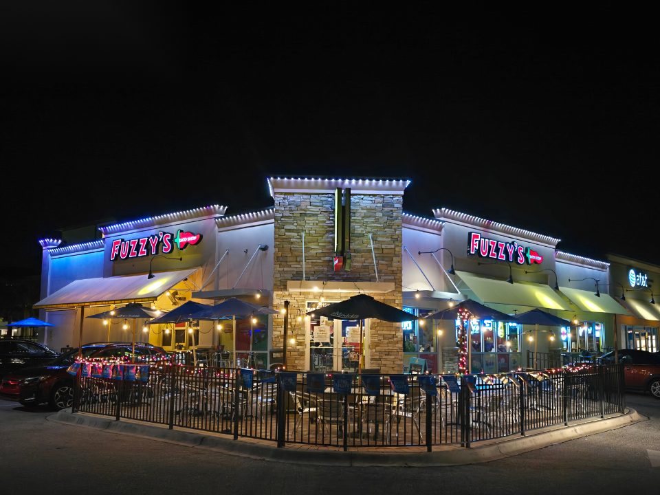 Restaurant patio and storefront with white permanent lighting