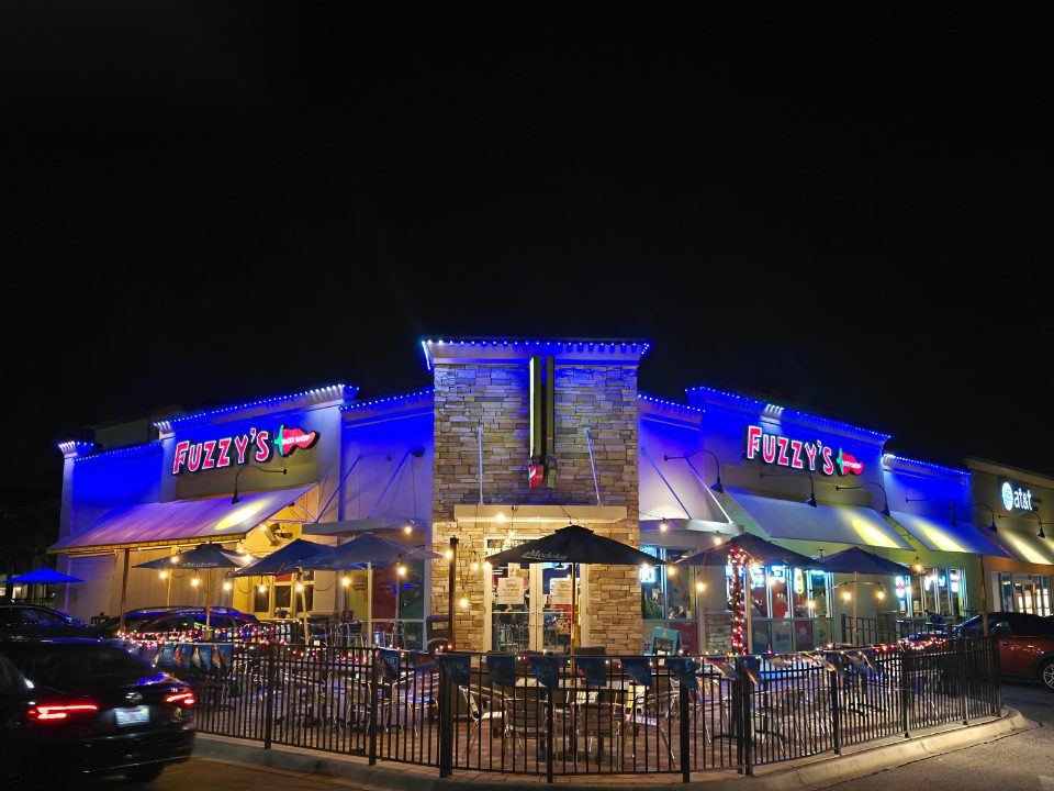 Restaurant storefront lit in blue permanent lighting