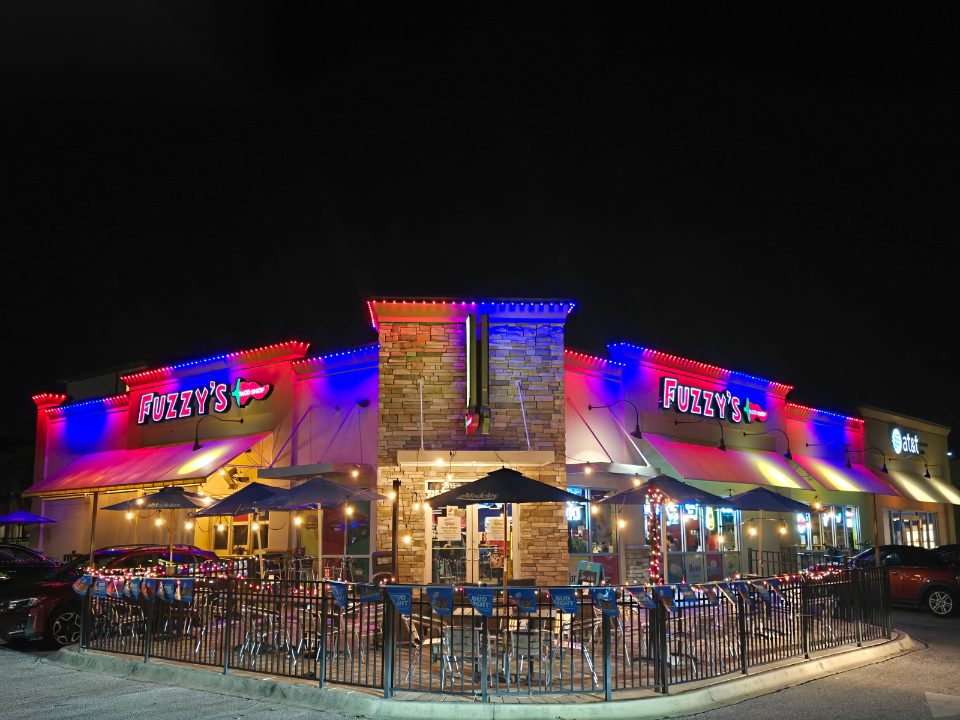 Restaurant storefront lit in red and blue permanent lighting