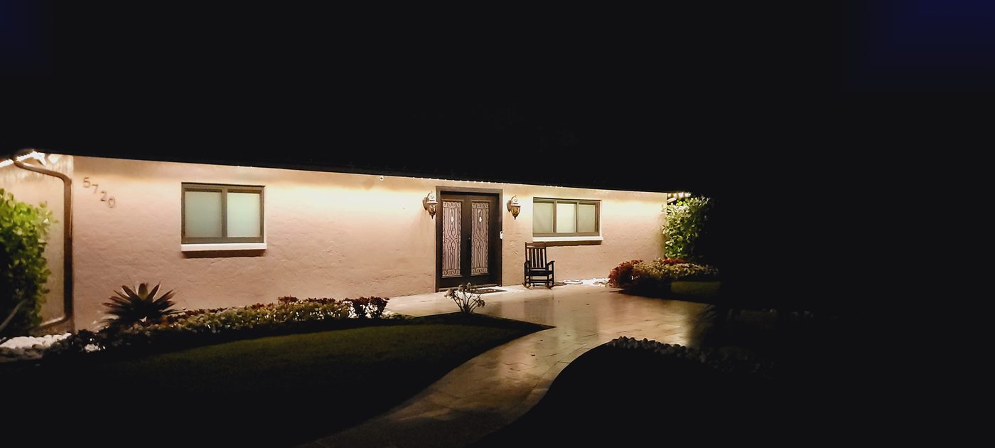 Home with warm accent lighting along the eaves and entryway