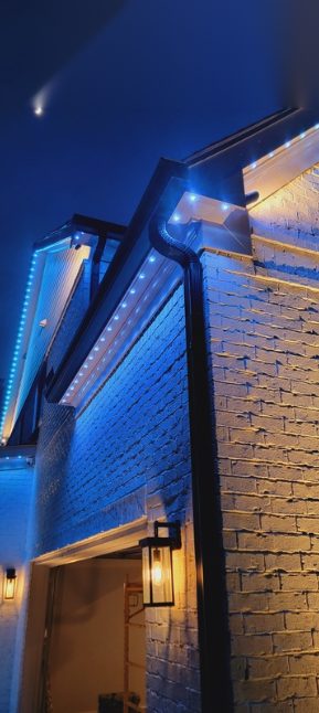Close-up of blue permanent lighting along a roofline and gutter