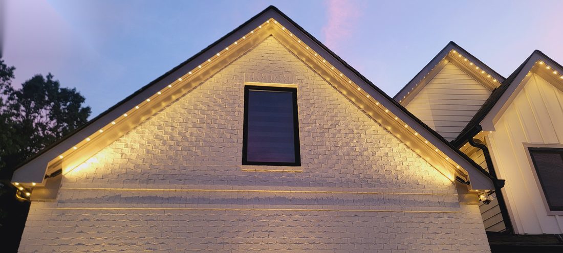 Close-up of warm white gable peak lighting at dusk