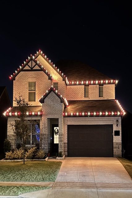 Home with red and warm white holiday lighting along the roofline